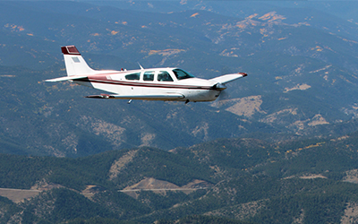 Cirrus aircraft flying over mountains